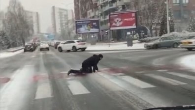 Ледено предизвикателство: Мъж лази в опит да пресече пешеходна пътека (+ВИДЕО)