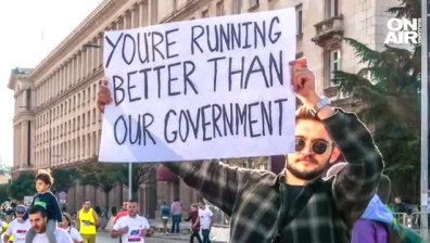 Млад мъж с плакат на маратона в София: "Вие бягате по-добре от нашето правителство"