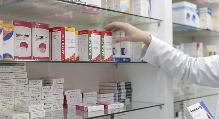Фармацевтът подава рецептата на робота и той търси лекарството.