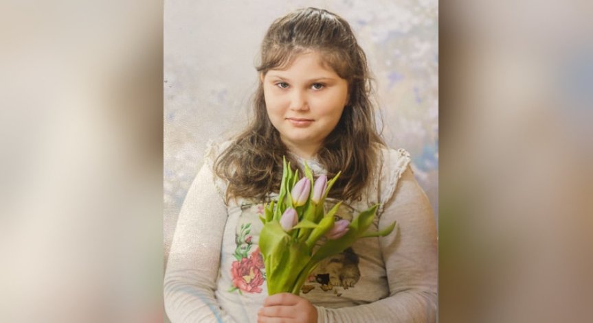 Облечена със синьо-бял гащеризон и кара черни ролери.